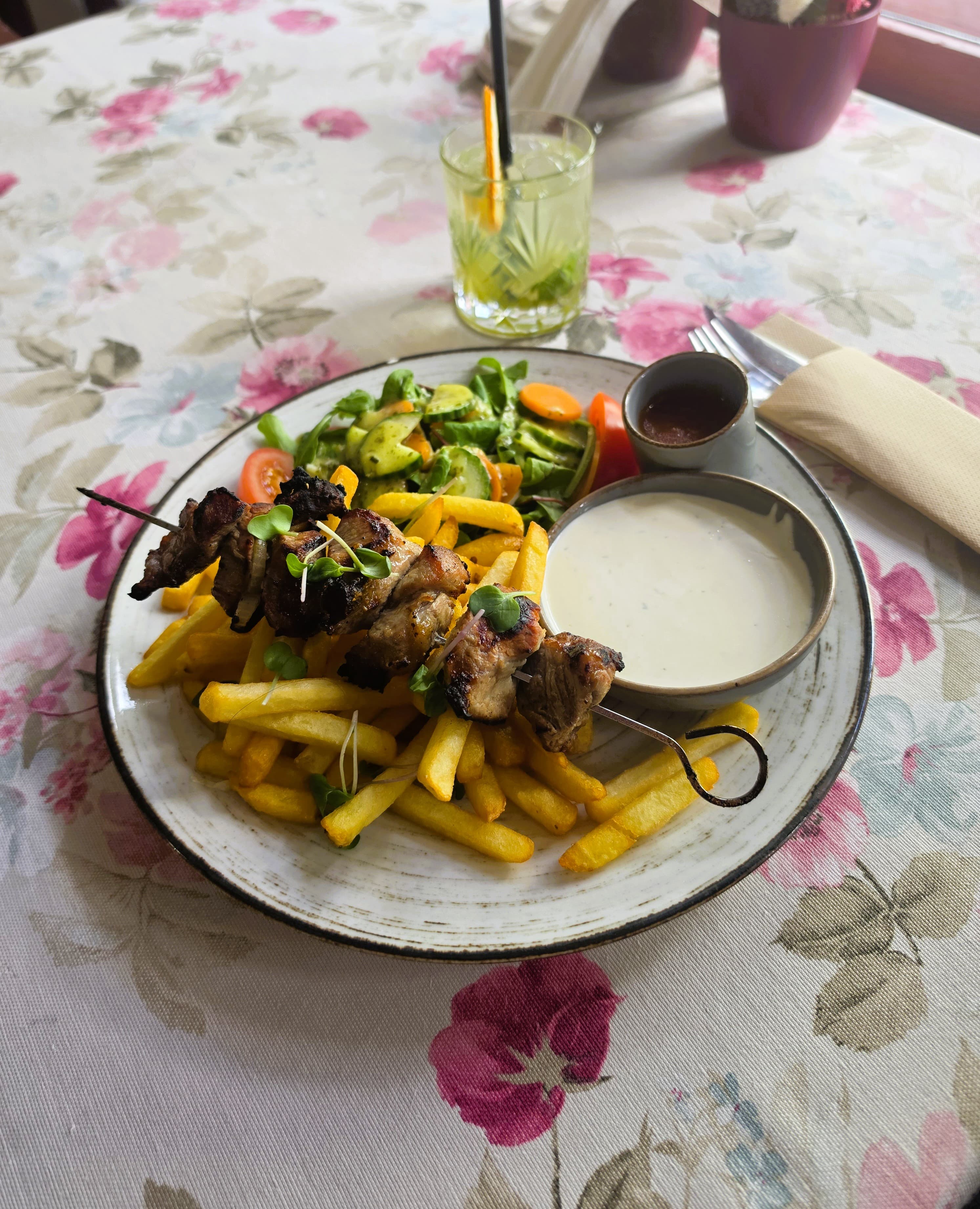 Kaetud laud grillvarraste, friikartulite ja kastmetega